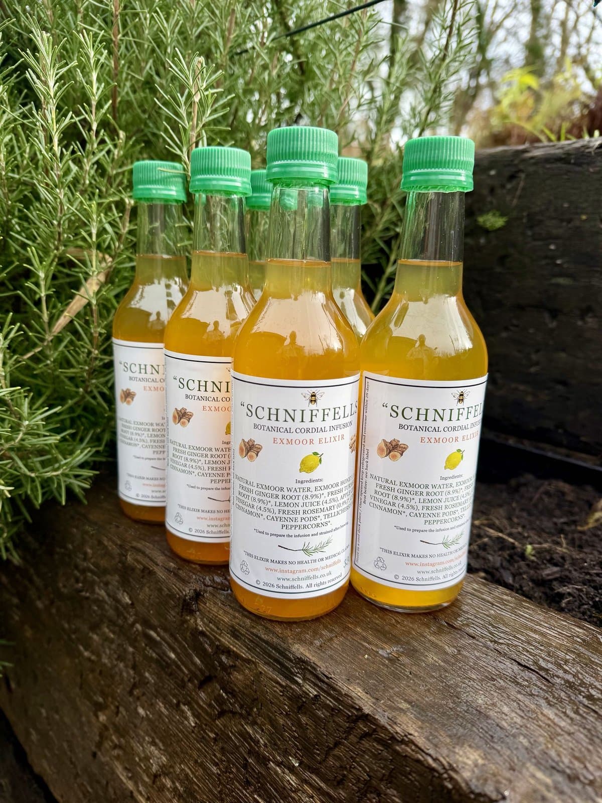 Six bottles of Schniffells lined up beside rosemary on Exmoor